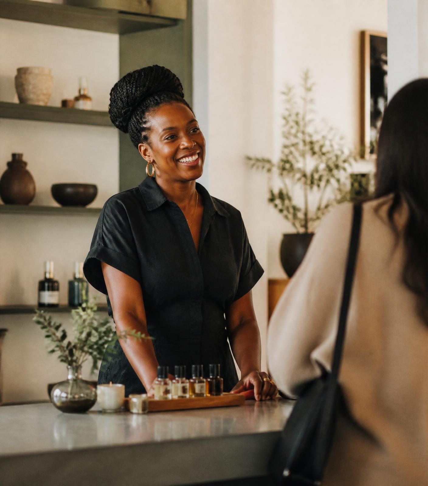 Independent shop owner greeting a customer at the counter